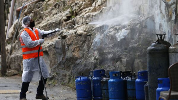 Palestinian worker sprays disinfectant as a preventive measure to help contain the coronavirus, in the West Bank city of Nablus, Wednesday, April 8, 2020.  - Sputnik International