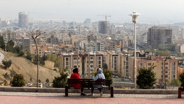 A general view of Tehran is seen as women sit on a bench, in Tehran, Iran April 15, 2020 - Sputnik International