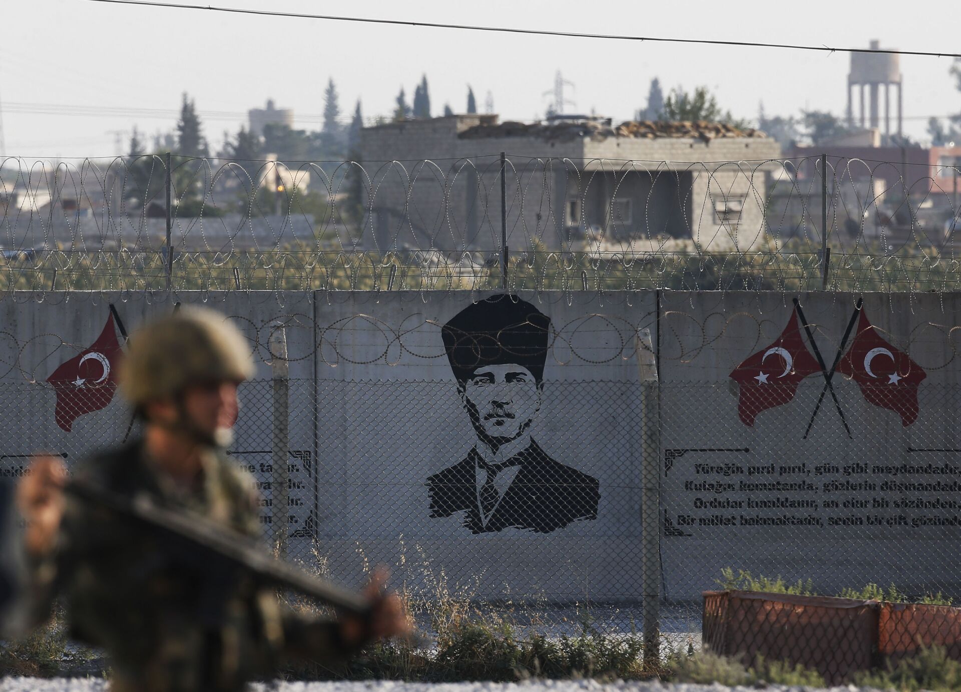 A Turkish soldier walks past Kemal Ataturk graffiti on a wall at the Syrian border - Sputnik International, 1920, 08.06.2022