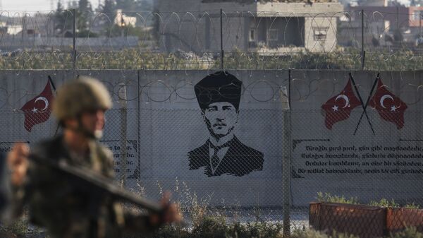 A Turkish soldier walks past Kemal Ataturk graffiti on a wall at the Syrian border - Sputnik International