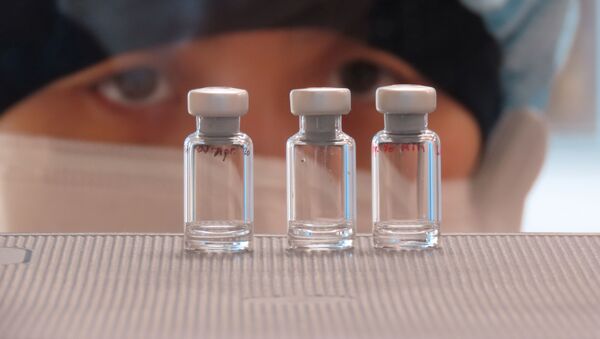 A scientist checks quality control of vaccine vials for correct volume at the Clinical Biomanufacturing Facility (CBF) in Oxford, Britain, April 2, 2020 - Sputnik International