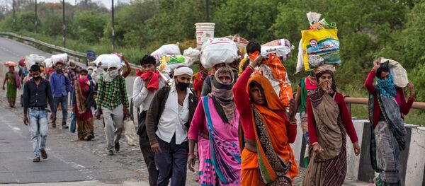 Friends and relatives of Kushwaha family who work as migrant workers walk along a road to return to their villages, during a 21-day nationwide lockdown to limit the spreading of coronavirus, in New Delhi, India, March 26, 2020 - Sputnik International