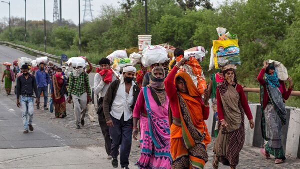 Friends and relatives of Kushwaha family members who work as migrantlabourers walk along a road to return to their villages, during a 21-day nationwide lockdown to limit the spreading of coronavirus, in New Delhi, India, 26 March 2020 - Sputnik International