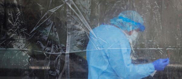 A healthcare worker administers a test for the coronavirus disease (COVID-19) at a drive-thru testing site in Providence, Rhode Island, U.S., April 23, 2020 - Sputnik International