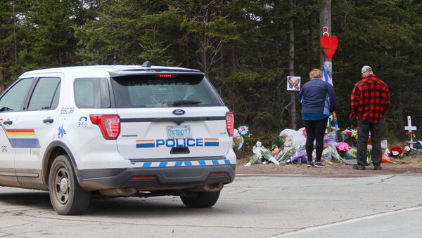 Mourners pay their respects in front of the makeshift memorial, made in the memory for the victims of Sunday’s mass shooting as a Royal Canadian Police Vehicle passes nearby in Portapique, Nova Scotia, Canada April 23, 2020 - Sputnik International