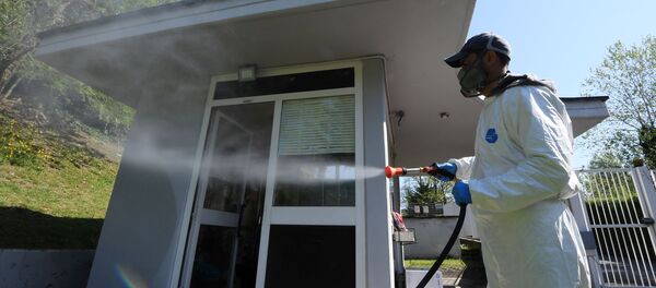A worker wearing protective clothing is seen spraying disinfectant towards a building in Via Cortina d’Ampezzo in Rome, as the spread of the coronavirus disease (COVID-19) continues, Rome, Italy, April 24, 2020. - Sputnik International