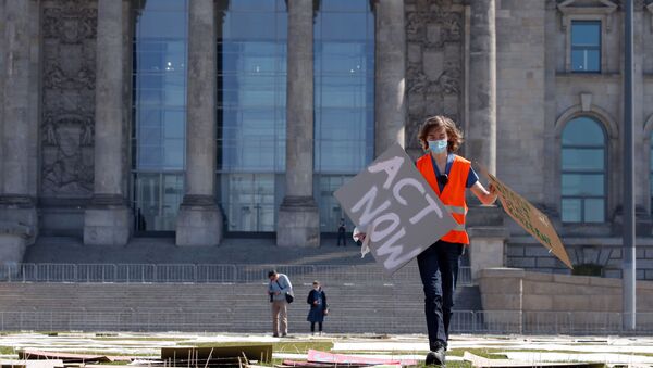 An activist of the Fridays for Future movement prepares a protest in front of the Reichstag building, the seat of the lower house of parliament Bundestag, as the spread of the coronavirus disease (COVID-19) continues in Berlin, Germany, April 24, 2020. R - Sputnik International