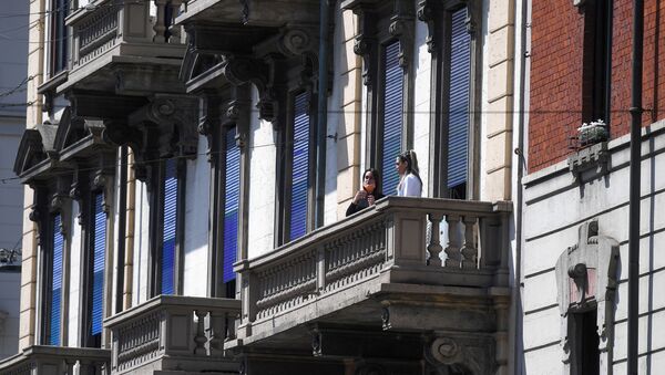 People wearing protective masks are pictured at a balcony during the coronavirus disease (COVID-19) outbreak, in Milan, Italy April 22, 2020. - Sputnik International