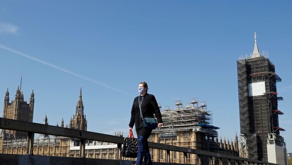 A woman wearing a face mask walks across Westminster Bridge with Big Ben clock and the Houses of Parliament in the background, as the spread of the coronavirus disease (COVID-19) continues, in London, Britain, April 23, 2020. REUTERS/John Sibley - Sputnik International