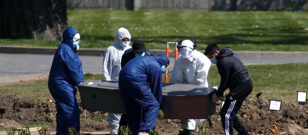 Workers wearing protective suits carry the coffin containing the body of a person at the Muslim cemetery Eternal Gardens in Kemnal Park Cemetery in Chislehurst, as the spread of the coronavirus disease (COVID-19) continues, London, Britain April 23, 2020. - Sputnik International