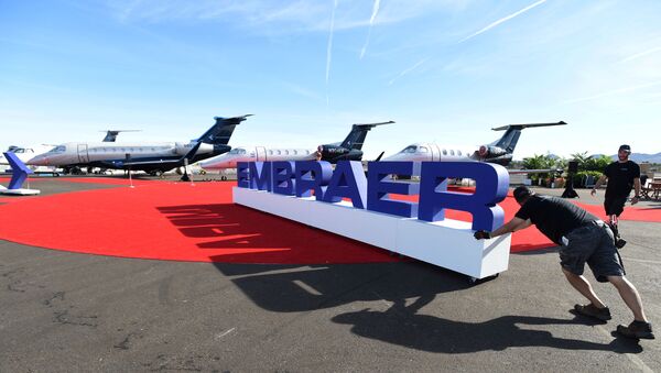 Workers set up at the Embraer booth prior to the opening of the National Business Aviation Association (NBAA) exhibition in Las Vegas, Nevada, U.S. October 21, 2019. - Sputnik International