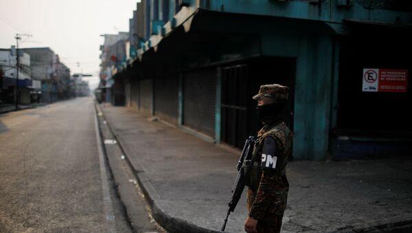 A military police officer stands close to a checkpoint during a police and army joint operation as part of security measures to keep people out of the city downtown markets during a quarantine throughout the country to curb the spread of the coronavirus disease (COVID-19), in San Salvador, El Salvador April 22, 2020. - Sputnik International