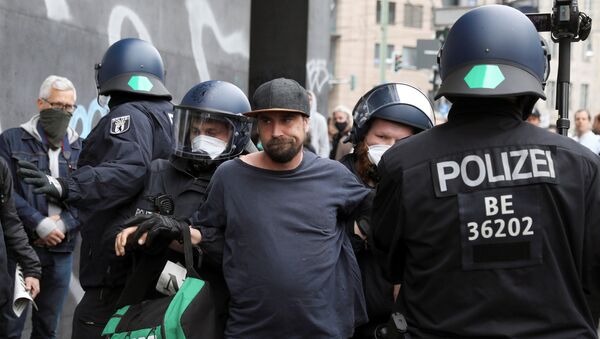 Police detain a protester during a demonstration against the lockdown imposed to slow down the spread of the coronavirus disease (COVID-19), in Berlin, Germany April 25, 2020. - Sputnik International