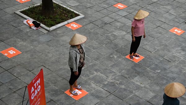 Люди сохраняют дистанцию в целях профилактики коронавируса в очереди за бесплатным рисом в Ханое, Вьетнам - Sputnik International