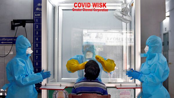 FILE PHOTO: A doctor in a protective chamber takes a swab from a man to test for coronavirus disease (COVID-19) at a newly installed Walk-In Sample Kiosk (WISK) in a government-run hospital in Chennai, India, April 13, 2020. - Sputnik International