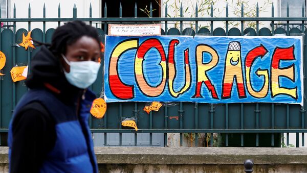 FILE PHOTO: A man wearing a protective mask walks past a sign that reads Courage, in Paris as a lockdown is imposed to slow the rate of the coronavirus disease (COVID-19) in France, April 25, 2020 - Sputnik International