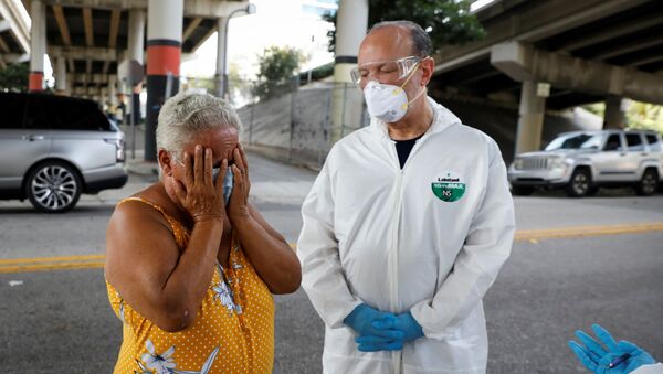 A homeless woman reacts next to a worker collecting samples during a Miami-Dade County testing operation for the coronavirus disease (COVID-19), in downtown Miami, Florida, U.S., April 16, 2020 - Sputnik International