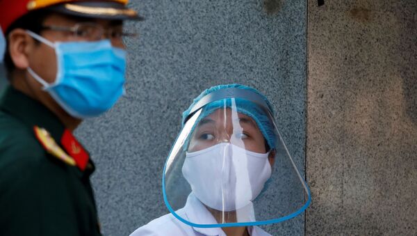 A health worker wears a protective face shield next to a soldier as they work at the quarantined Nephrology hospital during the coronavirus disease (COVID-19) outbreak in Hanoi, Vietnam April 14, 2020 - Sputnik International