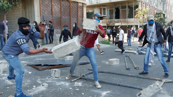 Demonstrators throw pieces of concrete during a protest against growing economic hardship in Beirut, Lebanon April 28, 2020 - Sputnik International