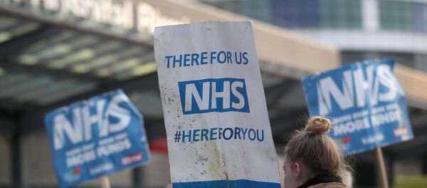 NHS signs are seen outside Queen Elizabeth Hospital during the Clap for our Carers campaign in support of the NHS, as the spread of the coronavirus disease (COVID-19) continues, in Birmingham, Britain, April 23, 2020.  - Sputnik International