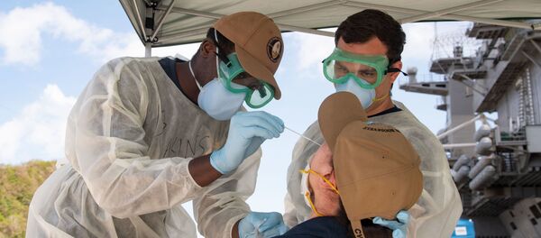 U.S. Navy Hospitalmen Christian Akins, left, from Atlanta, Ga., and Austin Brunt, from Charleston, S.C., assigned to Naval Hospital Guam, take a nasal sample from a U.S. Sailor assigned to the aircraft carrier USS Theodore Roosevelt (CVN 71) as part of a public health outbreak investigation April 23, 2020 U.S. Navy Hospitalmen Christian Akins, left, from Atlanta, Ga., and Austin Brunt, from Charleston, S.C., assigned to Naval Hospital Guam, take a nasal sample from a U.S. Sailor assigned to the aircraft carrier USS Theodore Roosevelt (CVN 71) as part of a public health outbreak investigation April 23, 2020 - Sputnik International