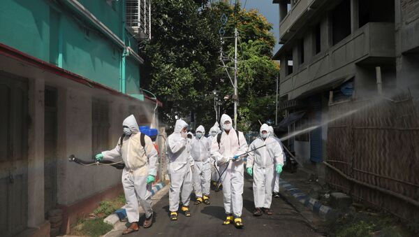 The spread of the coronavirus disease (COVID-19) in Kolkata Municipal workers wearing protective gear spray disinfectant in a residential area during a nationwide lockdown to slow the spreading of the coronavirus disease (COVID-19), in Kolkata, India, April 29, 2020.  - Sputnik International