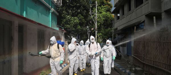 The spread of the coronavirus disease (COVID-19) in Kolkata Municipal workers wearing protective gear spray disinfectant in a residential area during a nationwide lockdown to slow the spreading of the coronavirus disease (COVID-19), in Kolkata, India, April 29, 2020.  - Sputnik International
