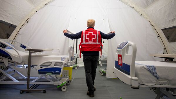 FILE PHOTO: A volunteer with the Red Cross shows a doorway between beds in a mobile hospital set up in partnership with the Canadian Red Cross in the Jacques-Lemaire Arena to help care for patients with the coronavirus disease (COVID-19) from long-term centres (CHSLDs), in Montreal, Quebec, Canada April 26, 2020 - Sputnik International