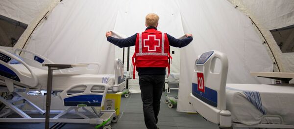 FILE PHOTO: A volunteer with the Red Cross shows a doorway between beds in a mobile hospital set up in partnership with the Canadian Red Cross in the Jacques-Lemaire Arena to help care for patients with the coronavirus disease (COVID-19) from long-term centres (CHSLDs), in Montreal, Quebec, Canada April 26, 2020 - Sputnik International