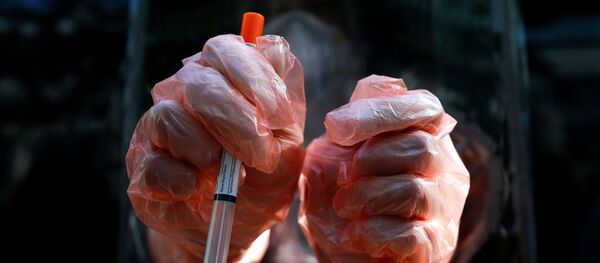 A medic wearing protective gloves shows a test kit as he works at a mobile laboratory for coronavirus disease (COVID-19) testing in Bangkok, Thailand, April 9, 2020.  - Sputnik International