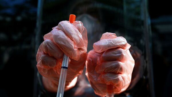 A medic wearing protective gloves shows a test kit as he works at a mobile laboratory for coronavirus disease (COVID-19) testing in Bangkok, Thailand, April 9, 2020.  - Sputnik International