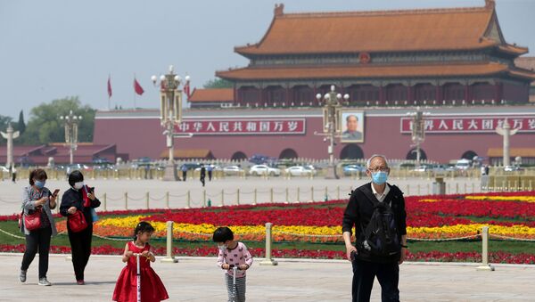 People wearing face masks following the coronavirus disease (COVID-19) outbreak walk past flower installations set up to mark the upcoming Labour Day holiday, at Tiananmen Square in Beijing, China, 29 April 2020 - Sputnik International