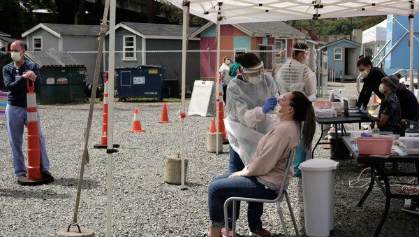 Physician Lauren Bernese administers a test for coronavirus disease (COVID-19) to Rachael Benson, a case manager at Interbay Village, a village of tiny houses managed by the Low Income Housing Institute, in Seattle, Washington, U.S. April 29, 2020 - Sputnik International