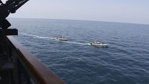 In this Wednesday, April 15, 2020, photo made available by U.S. Navy, Iranian Revolutionary Guard vessels sail close to U.S. military ships in the Persian Gulf near Kuwait - Sputnik International