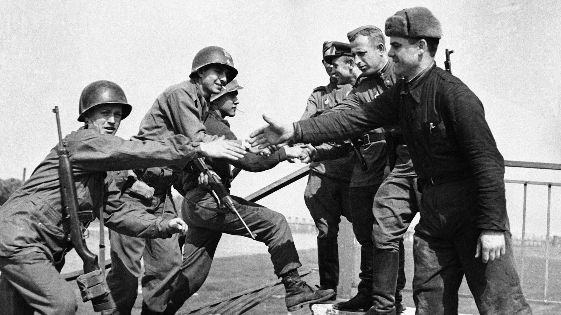 US and Soviet troops shaking hands after meeting up at Torgau on the Elbe river in Germany on 26 April 1945 - Sputnik International, 1920, 09.05.2023