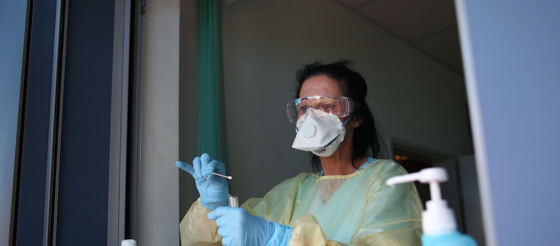 Nurse Sylke Pflugmacher takes a sample at a testing point for medical staff members at the community hospital in Magdeburg, eastern Germany, on April 16, 2020 during the novel coronavirus COVID-19 pandemic. - Sputnik International, 1920, 01.05.2020