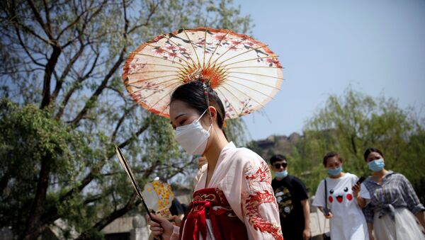 A woman wearing face mask and traditional Chinese clothing visits Gubei Water Town on the first day of the five-day Labour Day holiday, following the coronavirus disease (COVID-19) outbreak, on the outskirts of Beijing, China, May 1, 202 - Sputnik International