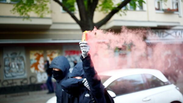 A protestor holds up a flare during a demonstration on May Day, amid the spread of the coronavirus disease (COVID-19), in Berlin, Germany May 1, 2020 - Sputnik International