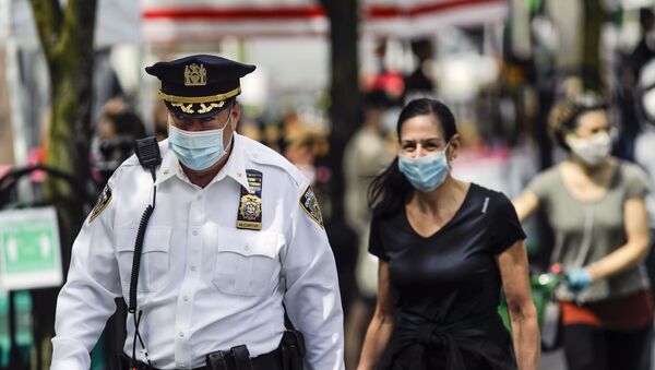 A police officer wears a protective mask as he walks among people at the Union Square GreenMarket Saturday, May 2, 2020, in New York - Sputnik International
