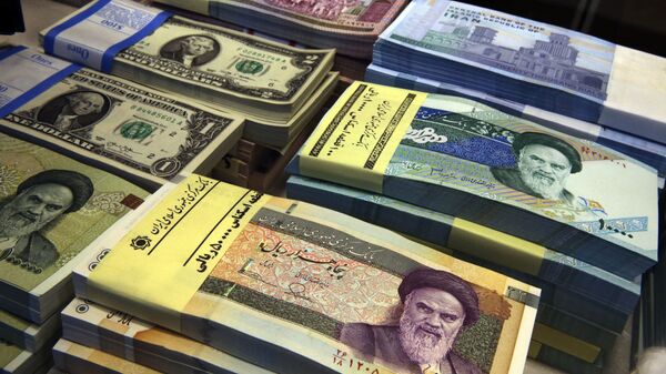 In this April 4, 2015 file photo, Iranian and U.S. banknotes are on display at a currency exchange shop in downtown Tehran, Iran. Iran's president has sent a bill to parliament that would cut four zeroes from value of the nation's sanctions-battered currency, the rial. Semi-official news agencies reported the news on Wednesday, Aug. 21, 2019, saying President Hassan Rouhani sent the bill with urgency to the parliament to consider. Iran's rial has been hammered by the effects of increasing U.S. sanctions on the country. - Sputnik International
