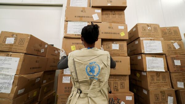 A World Food Program (WFP) worker arranges relief packages at a warehouse designated to the United Nations for humanitarian aid for Africa to combat the outbreak of the coronavirus disease (COVID-19), at the Bole International Airport in Addis Ababa, Ethiopia April 14, 2020. - Sputnik International