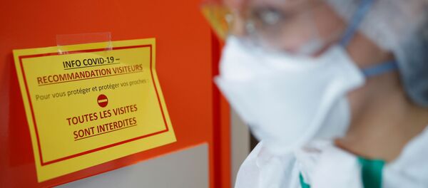 A nurse, wearing protective gear and face mask, walks past an information sign at the post COVID-19 unit of the Clinique Breteche private hospital in Nantes during the outbreak of the coronavirus disease (COVID-19) in France, April 30, 2020.  - Sputnik International