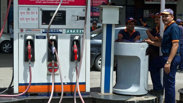 Employees of a petrol pump wait for customers in New Delhi on September 2, 2013. India is considering closing fuel pumps at night as one of a number of austerity measures aimed at cutting its ballooning oil import bills, the oil minister said. - Sputnik International