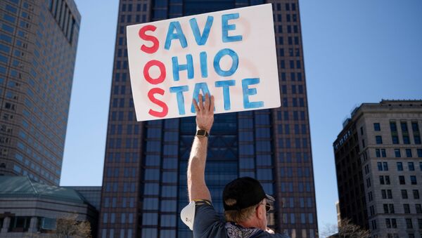  protester holds a placard during a demonstration against the state's extended stay-at-home order to help slow the spread of the Coronavirus disease (COVID-19) at the Capitol building in Columbus, Ohio, U.S. April 20, 2020 - Sputnik International