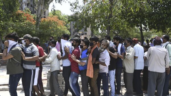 People queue to buy alcohol outside a liquor shop after the government eased a nationwide lockdown imposed as a preventive measure against the spread of the COVID-19 coronavirus in New Delhi on May 5, 2020.  - Sputnik International