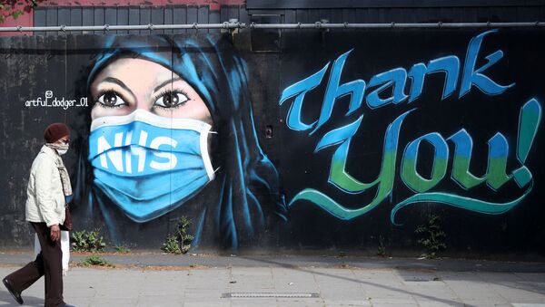 A person wearing a protective face mask walks past the 'NHS Dedication Mural’ by The Artful Dodger (A.Dee) in Elephant & Castle, following the outbreak of the coronavirus disease (COVID-19), London, Britain, 5 May 2020 - Sputnik International