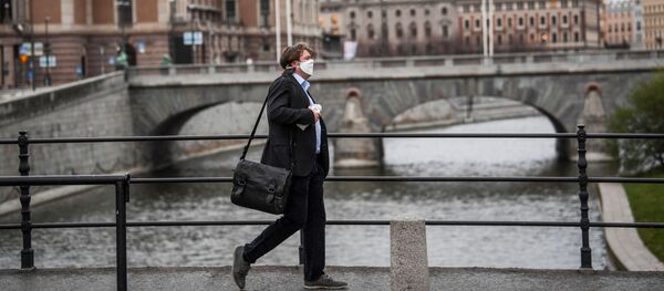 A man wearing a protective mask walks past the Royal Swedish Opera, amid the coronavirus disease (COVID-19) outbreak in Stockholm, Sweden, April 27, 2020 - Sputnik International
