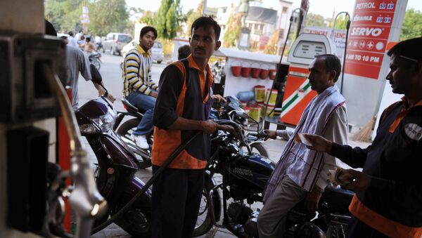 A petrol pump attendant (C, in orange) fills the fuel tank of a motorcycle in Allahabad (File) - Sputnik International