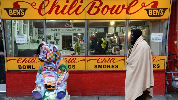 A member of the homeless community walks past Ben's Chili Bowl, whose founders Ben and Virginia Ali famously kept the restaurant running through very difficult times in the past, as the eatery navigates the coronavirus disease (COVID-19) outbreak with no seating, limited hours and help from a federal Payroll Protection Program Loan in Washington, U.S. April 30, 2020 - Sputnik International
