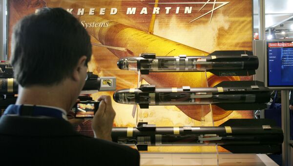 A visitor takes snapshots of models of missiles displayed in the Lockheed Martin stand, at the EuroSatory Defense Exhibition, outside Paris, Tuesday June 17, 2008.  - Sputnik International